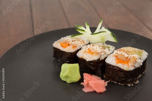 Three maki sushi served in black round plate