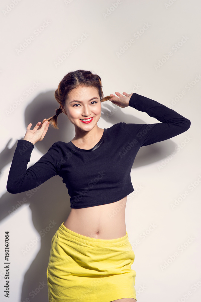 Young asian girl doing emotion. Dressed in a black shirt and yellow skirt. Warm color. White background, not isolated Young asian girl doing emotion. Dressed in a black shirt and yellow skirt. Warm color. White background, not isolated