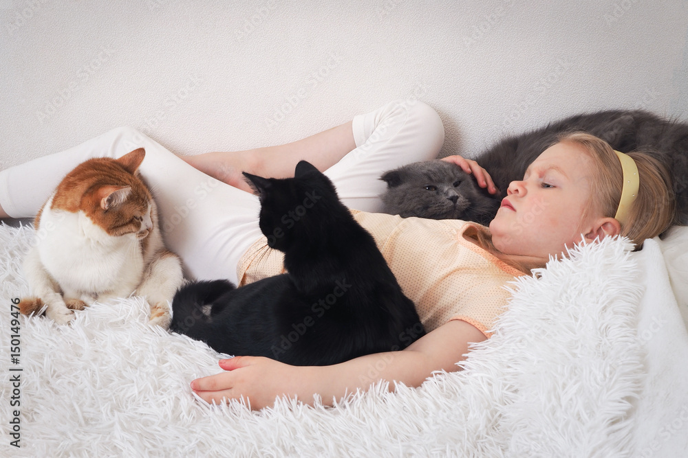 The child was lying on the bed with Pets cats The child was lying on the bed with Pets cats