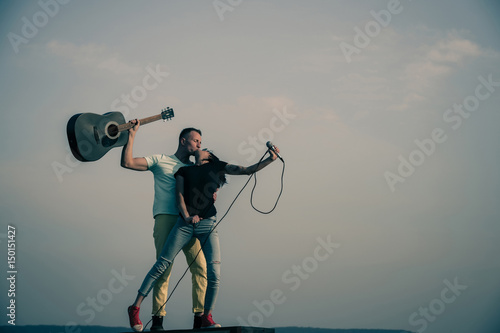 Photography Romantic couple of musicians kissing on idyllic, blue sky