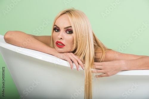 red lips and blonde hair of woman in bath tub