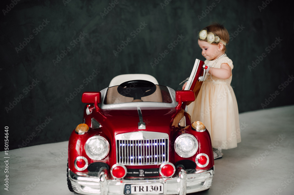 two babies wedding - girl dressed as bride playing with toy car