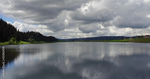 Lac des Tailleres - lake-close flight over lake with clouds reflection 2- La Brevine