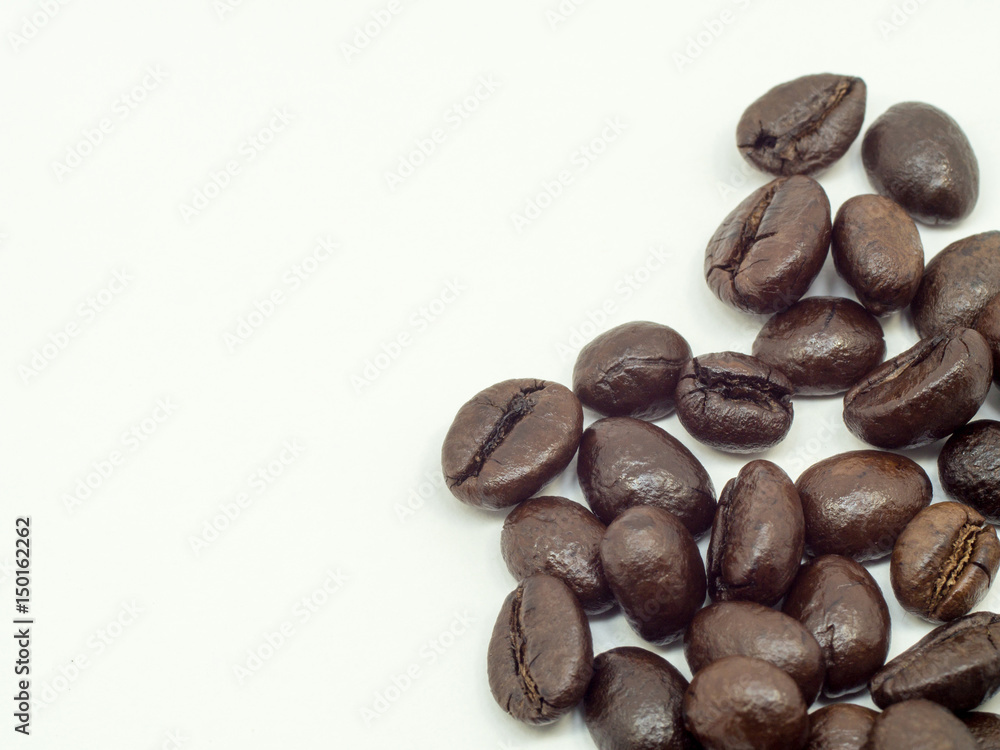 A group of thin coffee beans are on a white background. A group of thin coffee beans are on a white background.