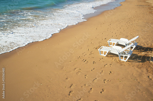two loungers on the beach near the shore