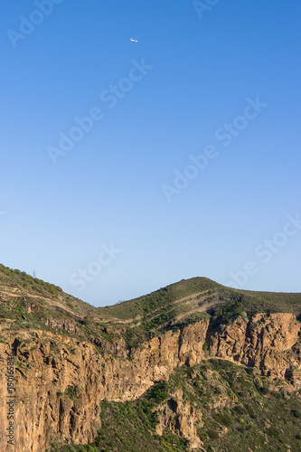 Airplane Flying over a Mountain Range (Blue Sky) © J.M. Image Factory