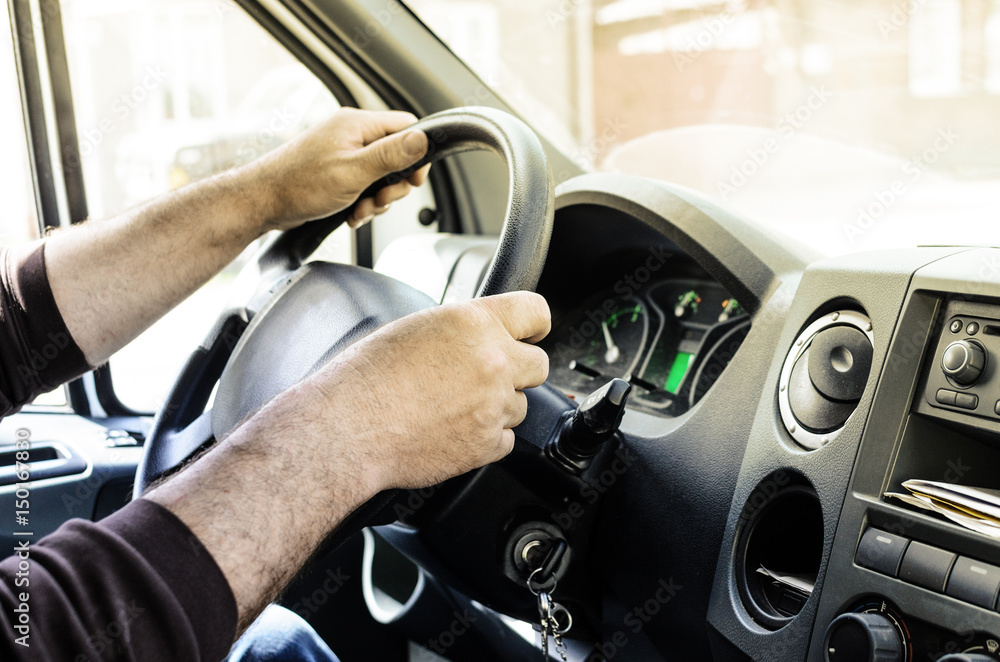 Male Mens hands on the wheel of a big car in the cabin