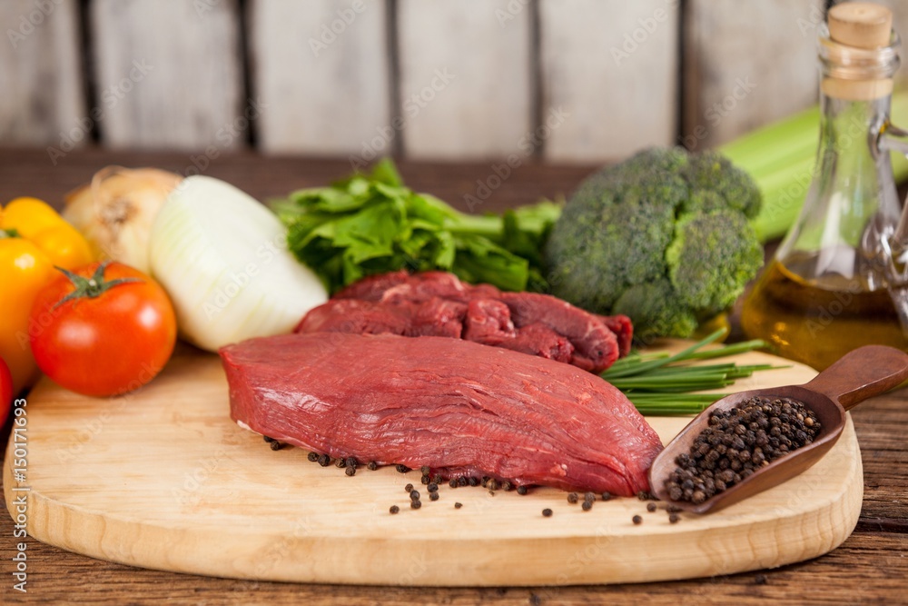 Beef steak on wooden board with ingredients Beef steak on wooden board with ingredients