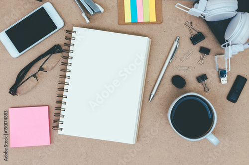 Top view of a wooden desk with notepad  sticky notes  pencil and clock with copy space