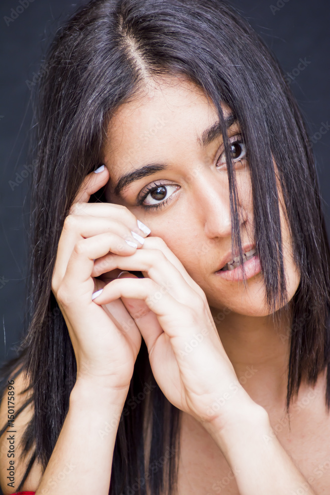 Portrait of a beautiful woman leaning her cheek on her hands Portrait of a beautiful woman leaning her cheek on her hands