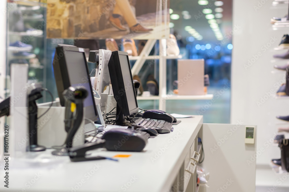 Two cash desks with computer screens and barcode scanners on white table and wall in small store Two cash desks with computer screens and barcode scanners on white table and wall in small store