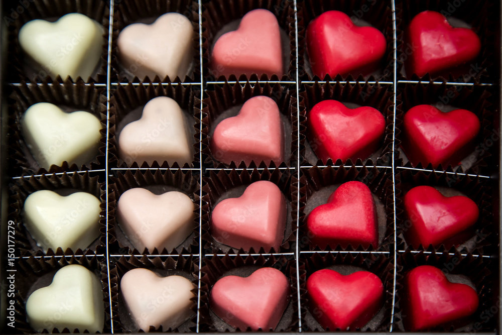 Delicious heart-shaped chocolate pralines on a black background image. Delicious heart-shaped chocolate pralines on a black background image.