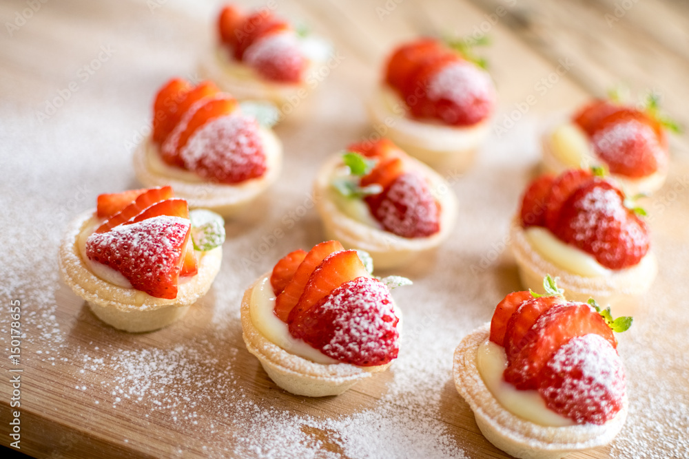 mini strawberry tarts on wood background