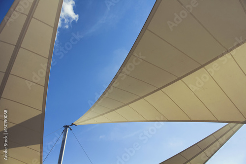 Bottom view of triangle shaped big sun shades and clear blue sky in the background in Bodrum which is Aegean coastal city of Turkey.