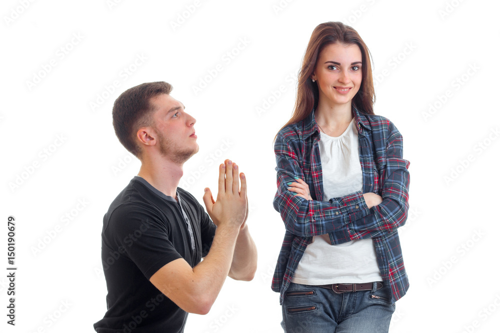 young guy kneels before a girl back together and she looks right and smiling young guy kneels before a girl back together and she looks right and smiling