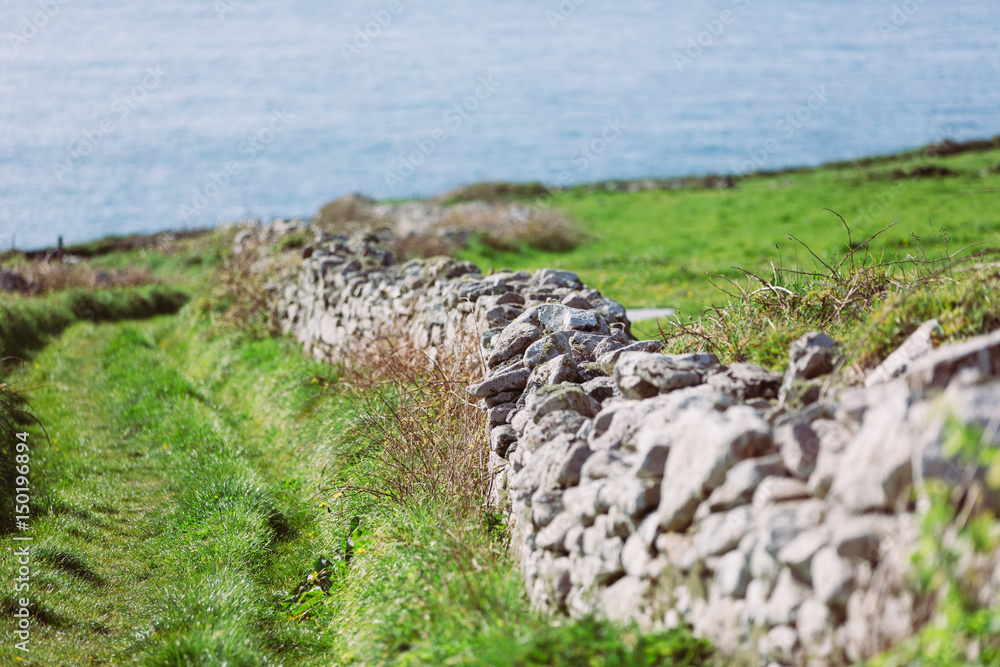 Stone wall and coast footpath with ocean view
