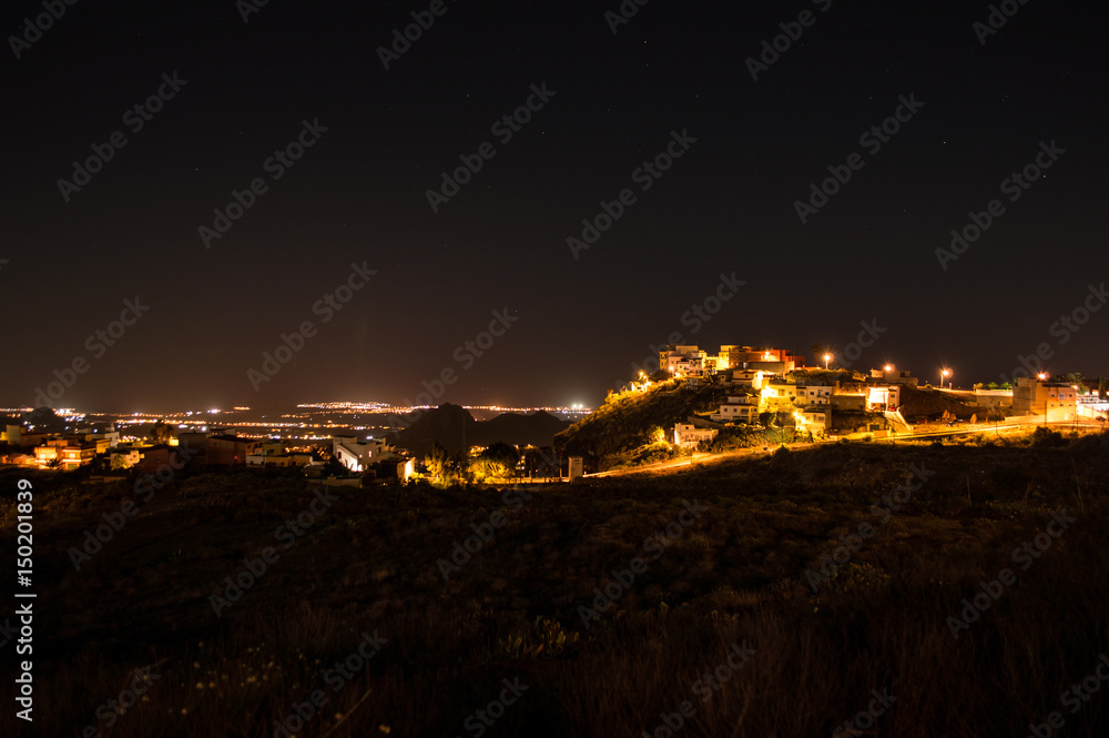 Beautiful Night Shot of Illuminated Spanish Village on a Hill with Meadow, Landscape View and Stars, Tenerife, Canary Islands
