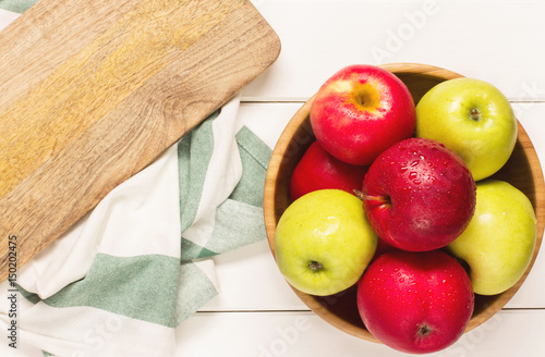 Red and green apples on a white wooden background, horizontal, soft focus, top view 
