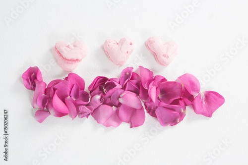 Heart shaped confectionery and pink rose petals