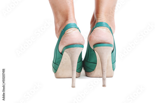 Slender female legs in green high-heeled shoes