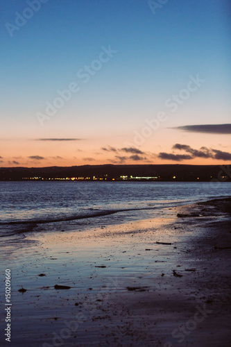Fototapeta Naklejka Na Ścianę i Meble -  Sunset on beach with citylights