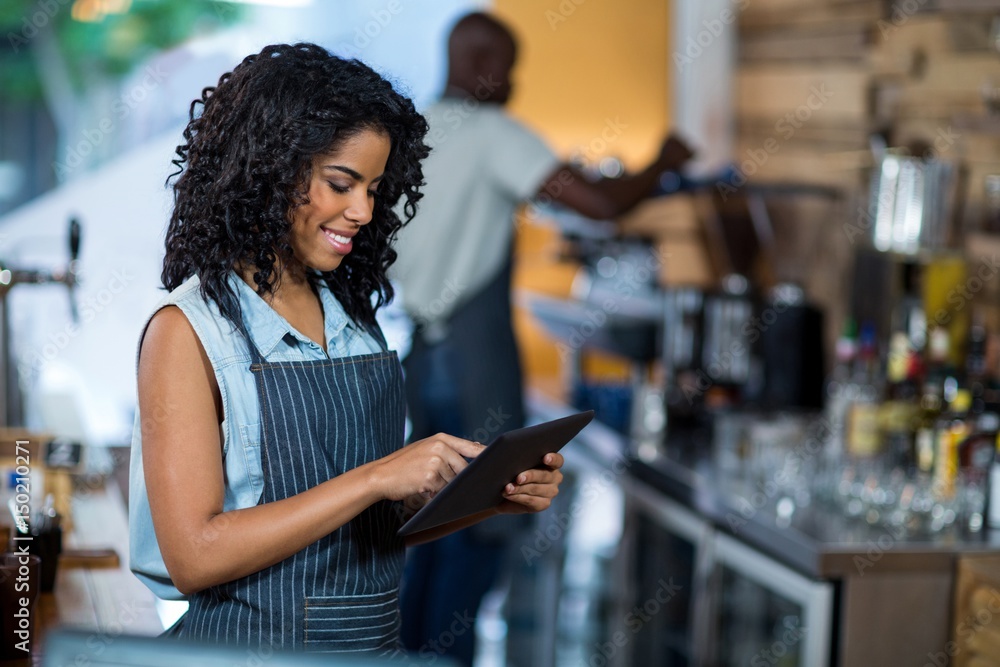 Smiling waitress using digital tablet Smiling waitress using digital tablet