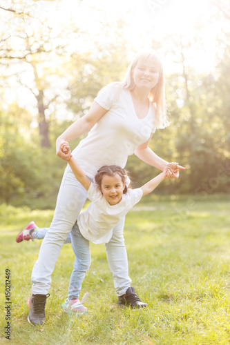sporty mother and daughter. woman and child training in the park. outdoor sports. healthy sport lifestyle. fitness, yoga