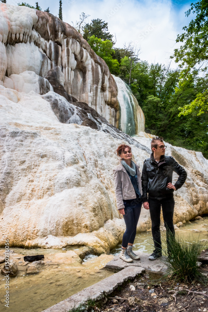 Femme et Jeune homme devant Les thermes Bagni di San Filippo en Toscane Femme et Jeune homme devant Les thermes Bagni di San Filippo en Toscane