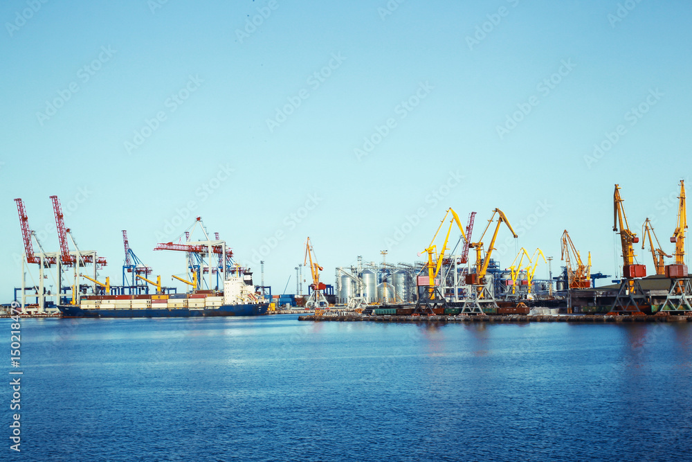 Panorama of a seaport with cargo cranes and a ship with freight containers