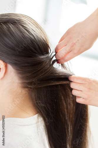 Hairdresser does hair style of woman