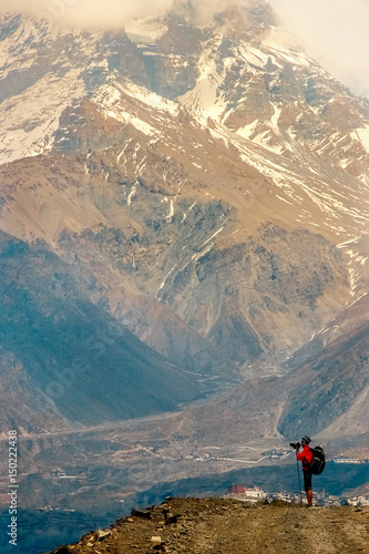 A small figure of a man against the background of large mountains. The Kingdom of "Lower Mustang". Nepal.