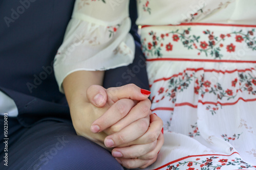 Couple holding hands while sitting together