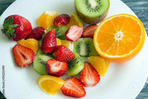 Sliced fruit on a white plate. Delicious dessert. Healthy food.