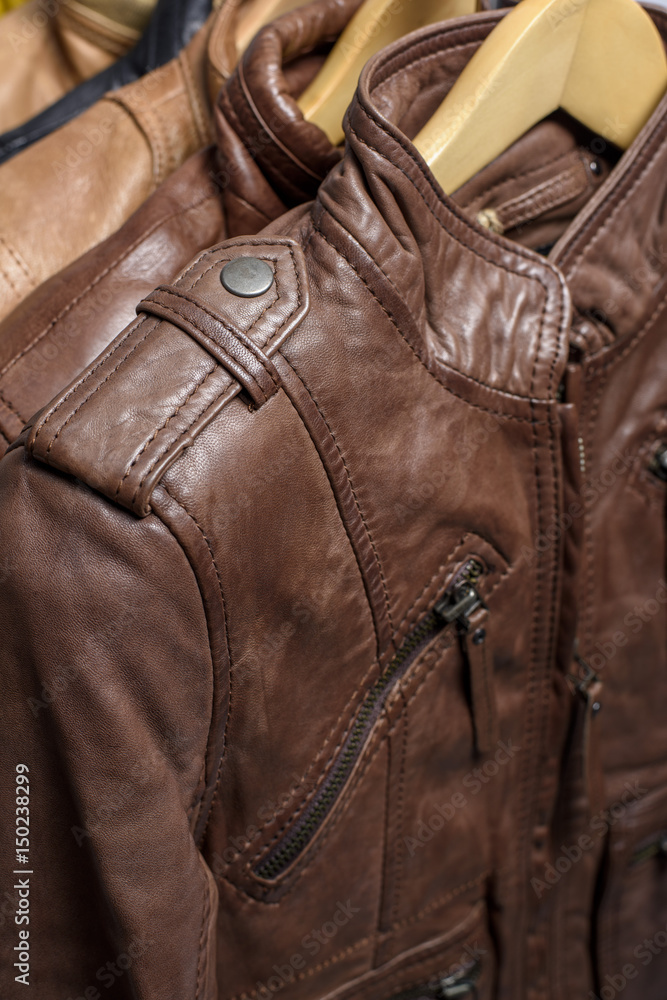 Different color leather jacket hanging on rack on white background Different color leather jacket hanging on rack on white background