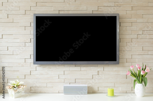 Blank modern flat screen TV at the white brick wall with copy space