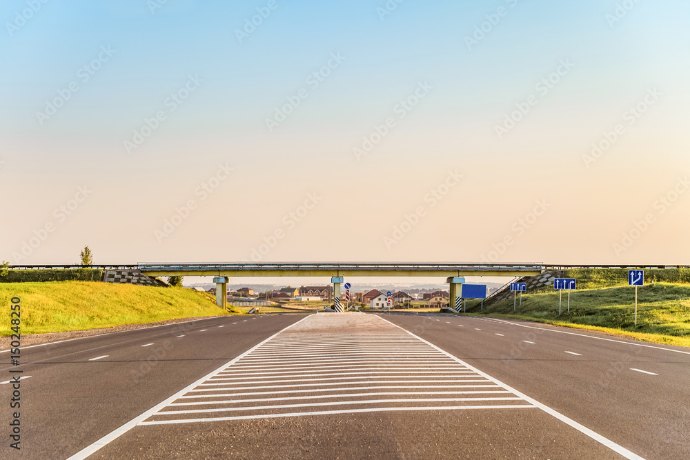 Multi-lane countryside asphalt road with marking. Intersection of the country roads on two levels. Disappearing into the distance perspective. Belgorod region, Russia. - obrazy, fototapety, plakaty 