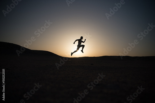 running man silhouette at sunset sky