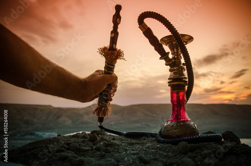 Hookah, traditional arabic waterpipe, direct sunset light, outdoor photo photo