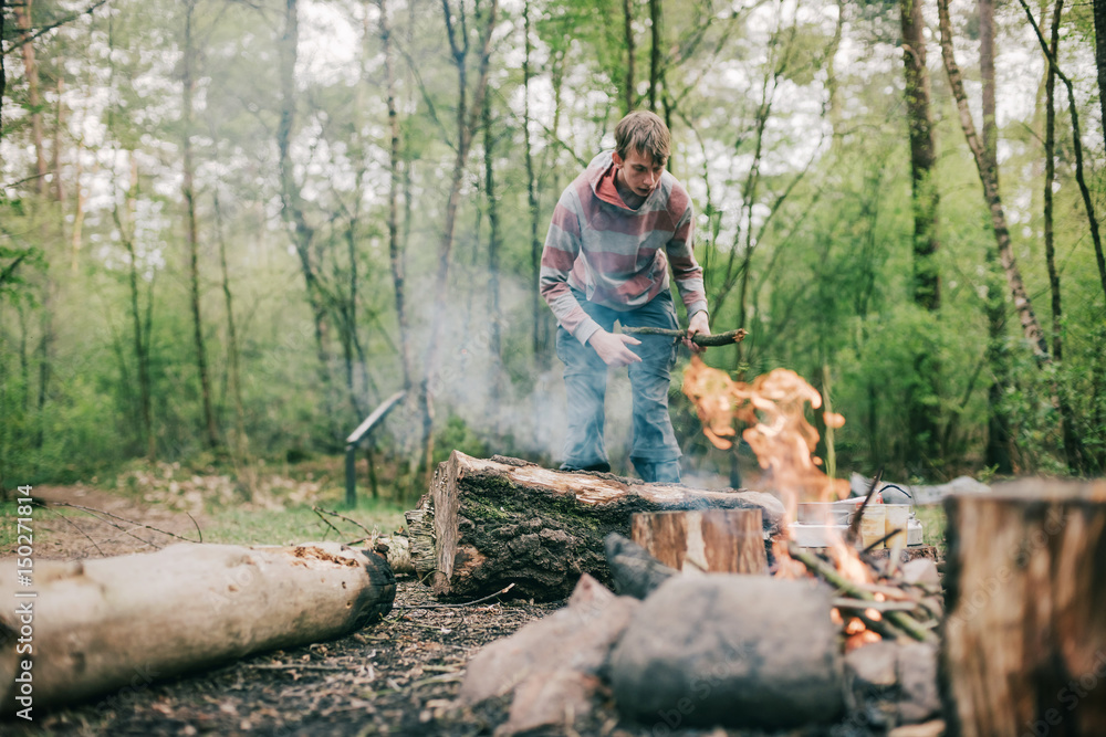 Nomad creating a campfire in spring forest. Nomad creating a campfire in spring forest.
