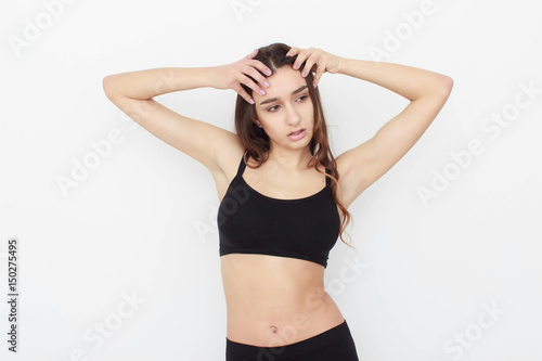 Beautiful girl in black top on white background shows emotion © Saksoni