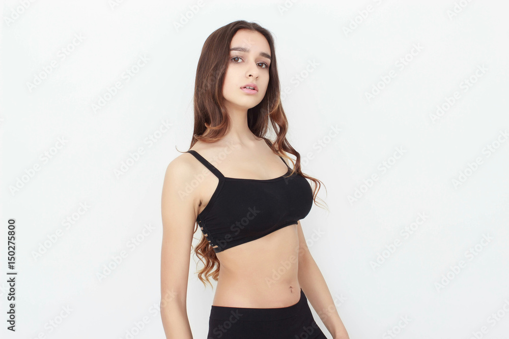 Fototapeta premium Beautiful girl in black top on white background shows emotion