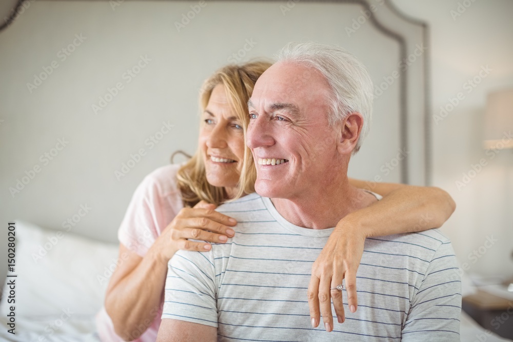 Smiling woman embracing man on bed Smiling woman embracing man on bed