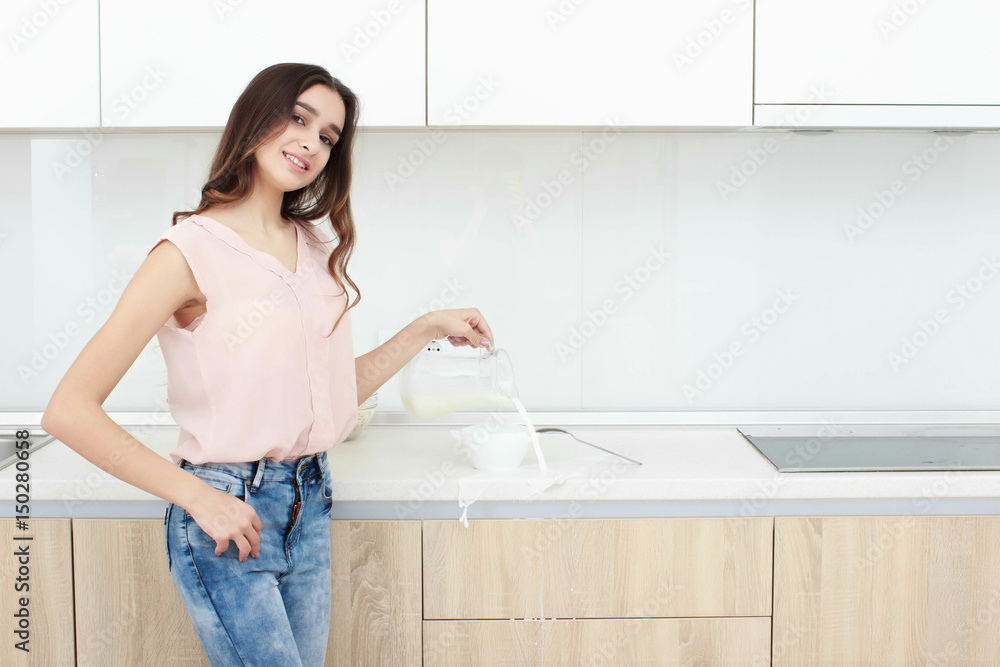 Woman pouring milk on plate with cereal muslin at kitchen Woman pouring milk on plate with cereal muslin at kitchen