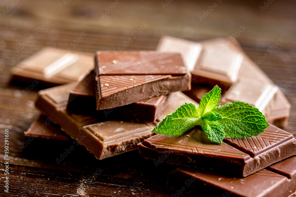black and milk chocolate bars with mint dark wooden table background black and milk chocolate bars with mint dark wooden table background