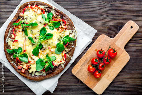 cooking pizza with vegetables and cheese on wooden desk background top view