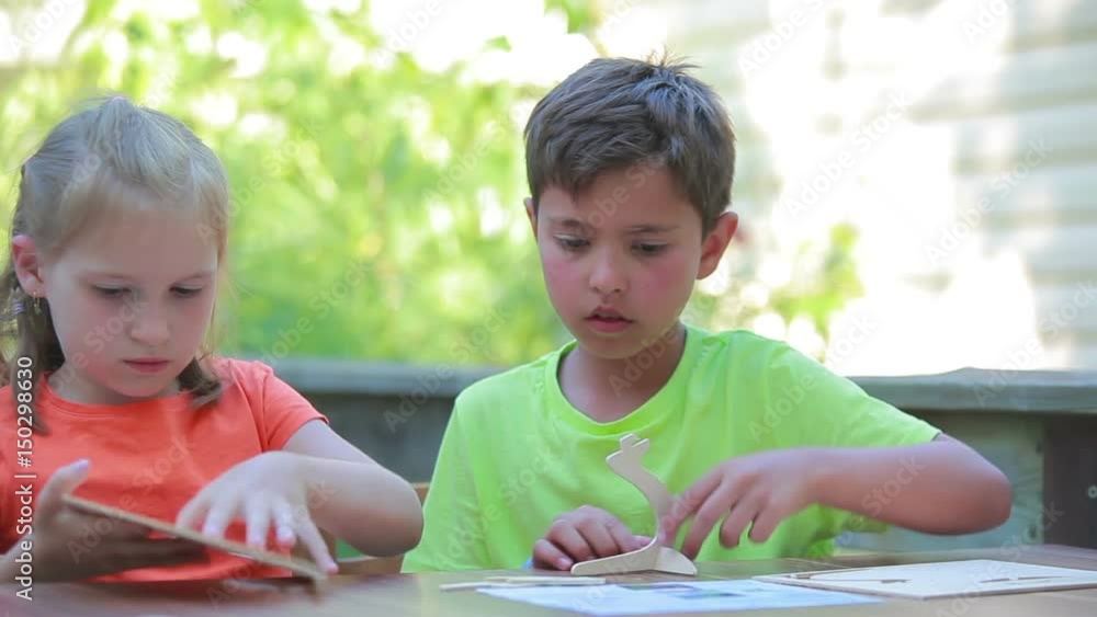 Boy and girl collect model from the designer outdoors in summer day Boy and girl collect model from the designer outdoors in summer day