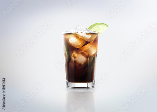 Famous classic / popular cocktail drink: Cuba Libre. Made with rum, coke, lemon / lime and ice. Isolated on white background.