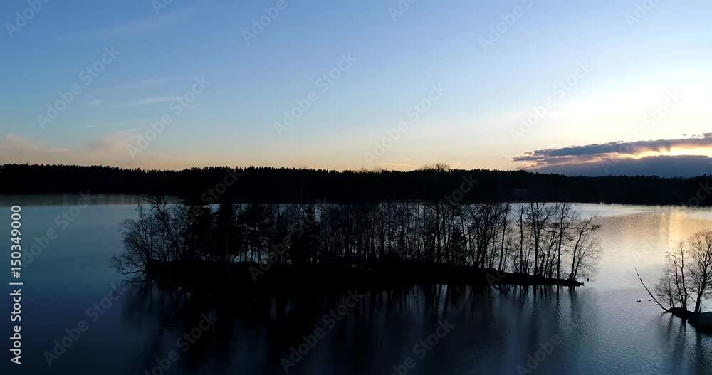 Lake bodom, Cinema 4k aerial orbit view around a little island on mirroring bodom lake, on a sunny spring evening, in Espoo, Finland Lake bodom, Cinema 4k aerial orbit view around a little island on mirroring bodom lake, on a sunny spring evening, in Espoo, Finland