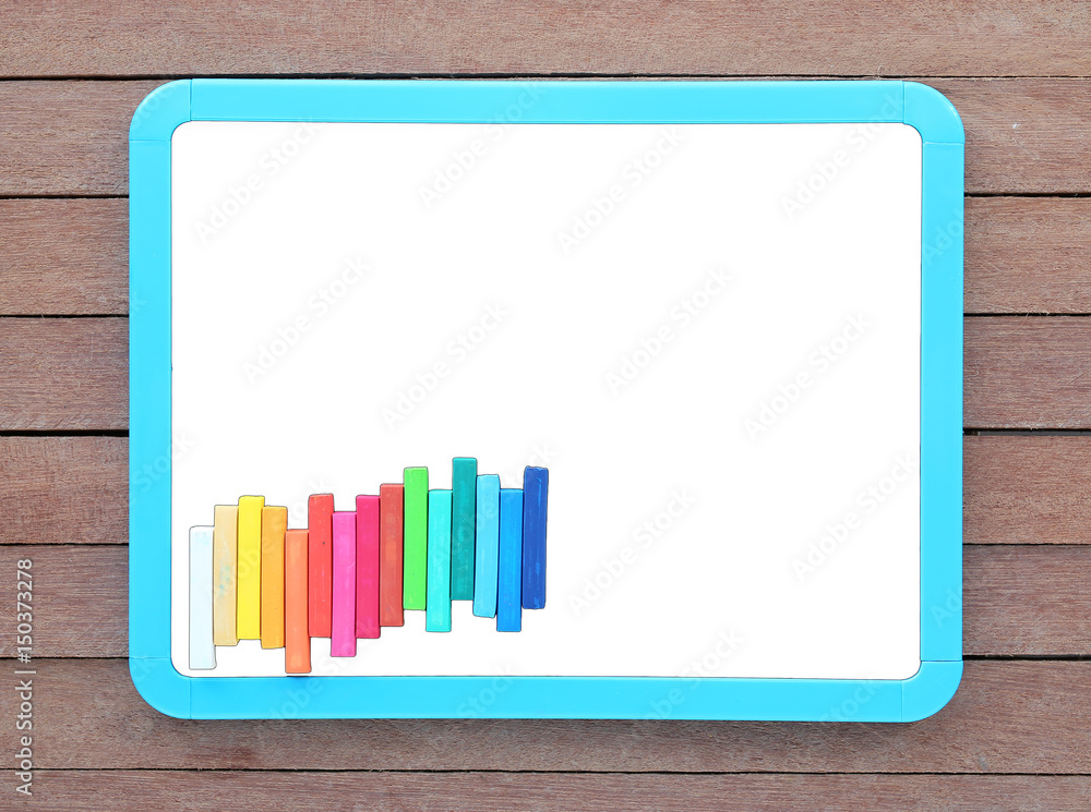 Blank white blackboard with colorful chalk on wooden plank. Blank white blackboard with colorful chalk on wooden plank.