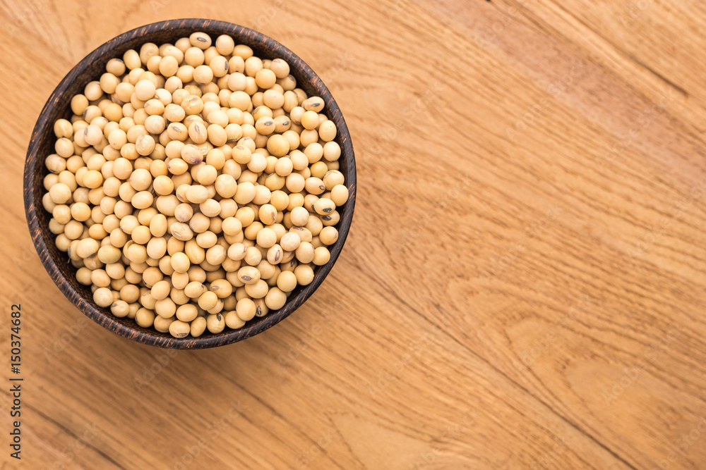 Soybean in wooden bowl put on wooden plank background Soybean in wooden bowl put on wooden plank background